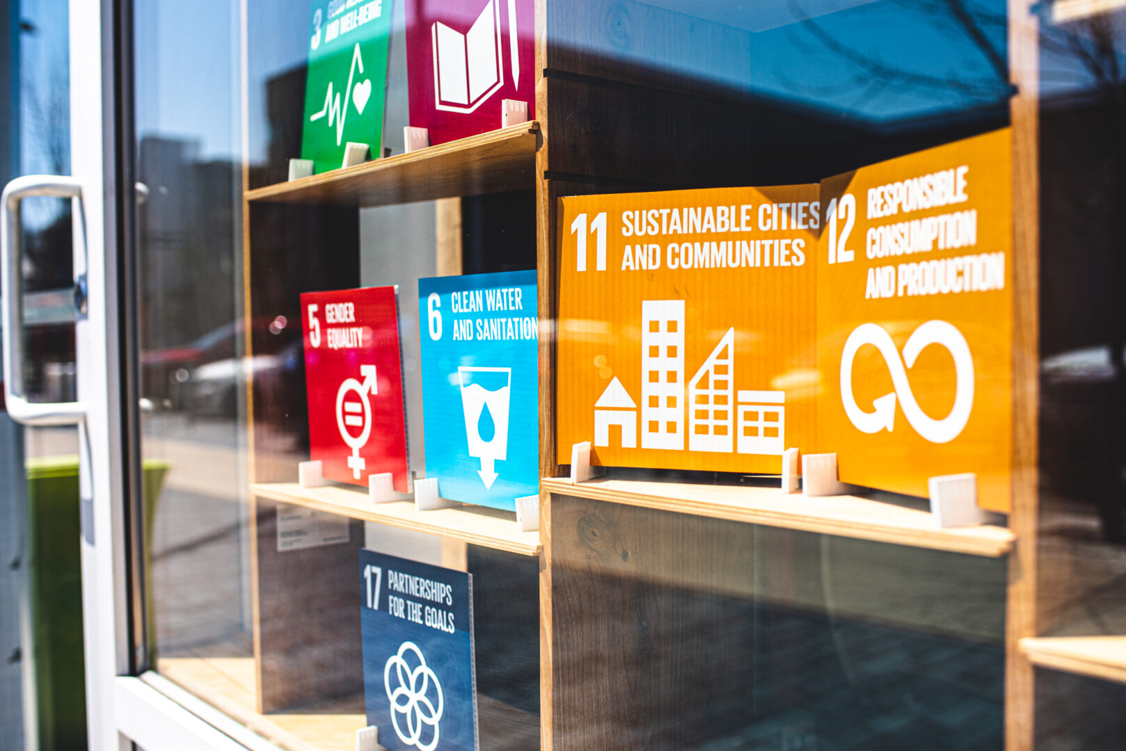 Printed posters showing the UN Sustainable Development Goals peek through the front windows at 10C Shared Space. 