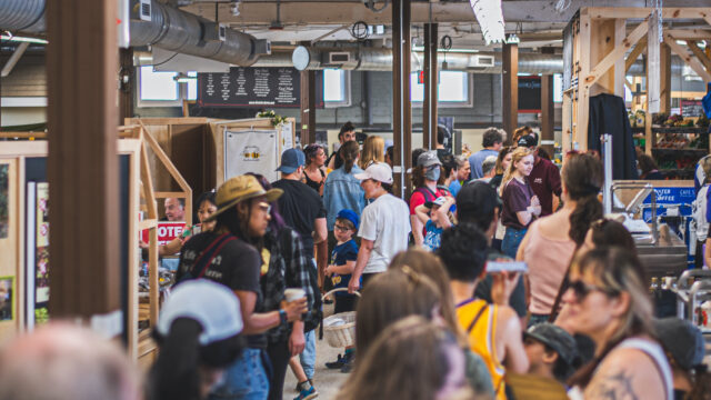 Many people shopping in an indoor farmers' market