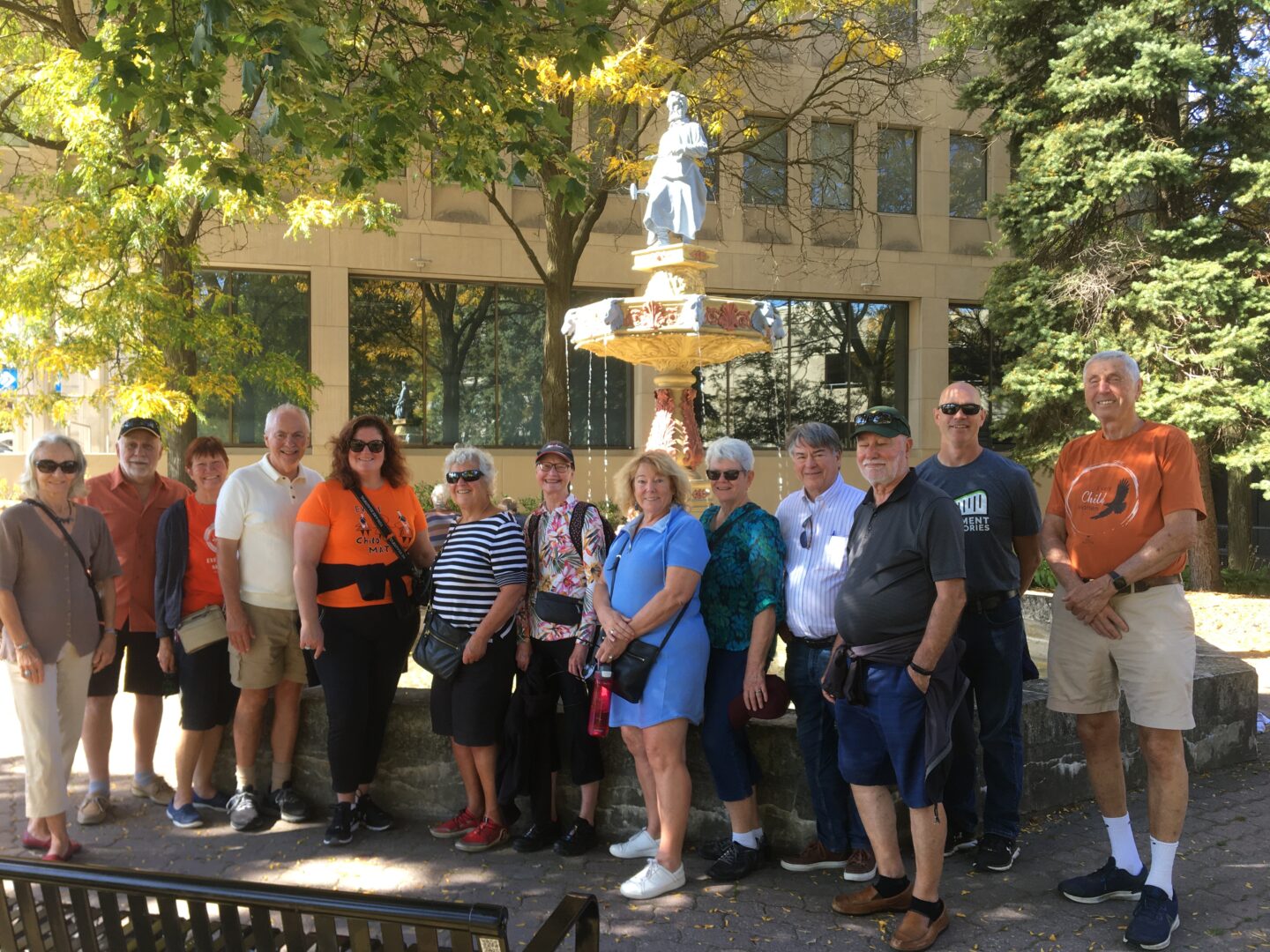 Group of people posing together in front of a fountain - they are on a walking tour
